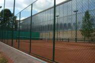 Теннисный корт, огороженный сеткой Рабица